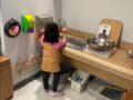 A Montessori student is washing dishes in the kitchen